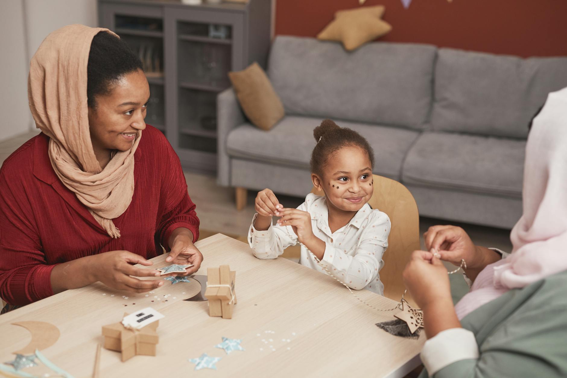 Trzy pokolenia rodziny wykonujące rękodzieło przy stole w domu