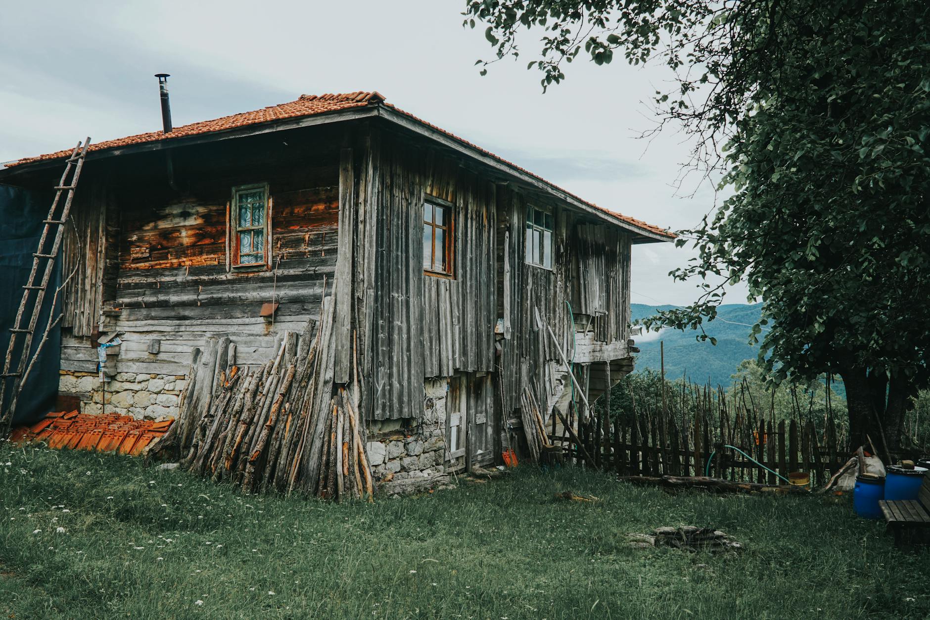 Drewniany, wiejski dom wśród zieleni na tle górskiego krajobrazu
