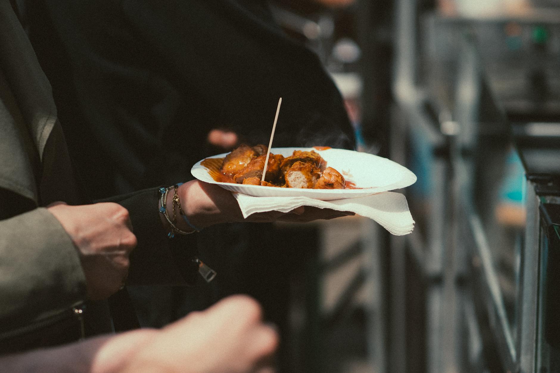Talerz lokalnego street foodu trzymany na weekendowym targu na świeżym powietrzu