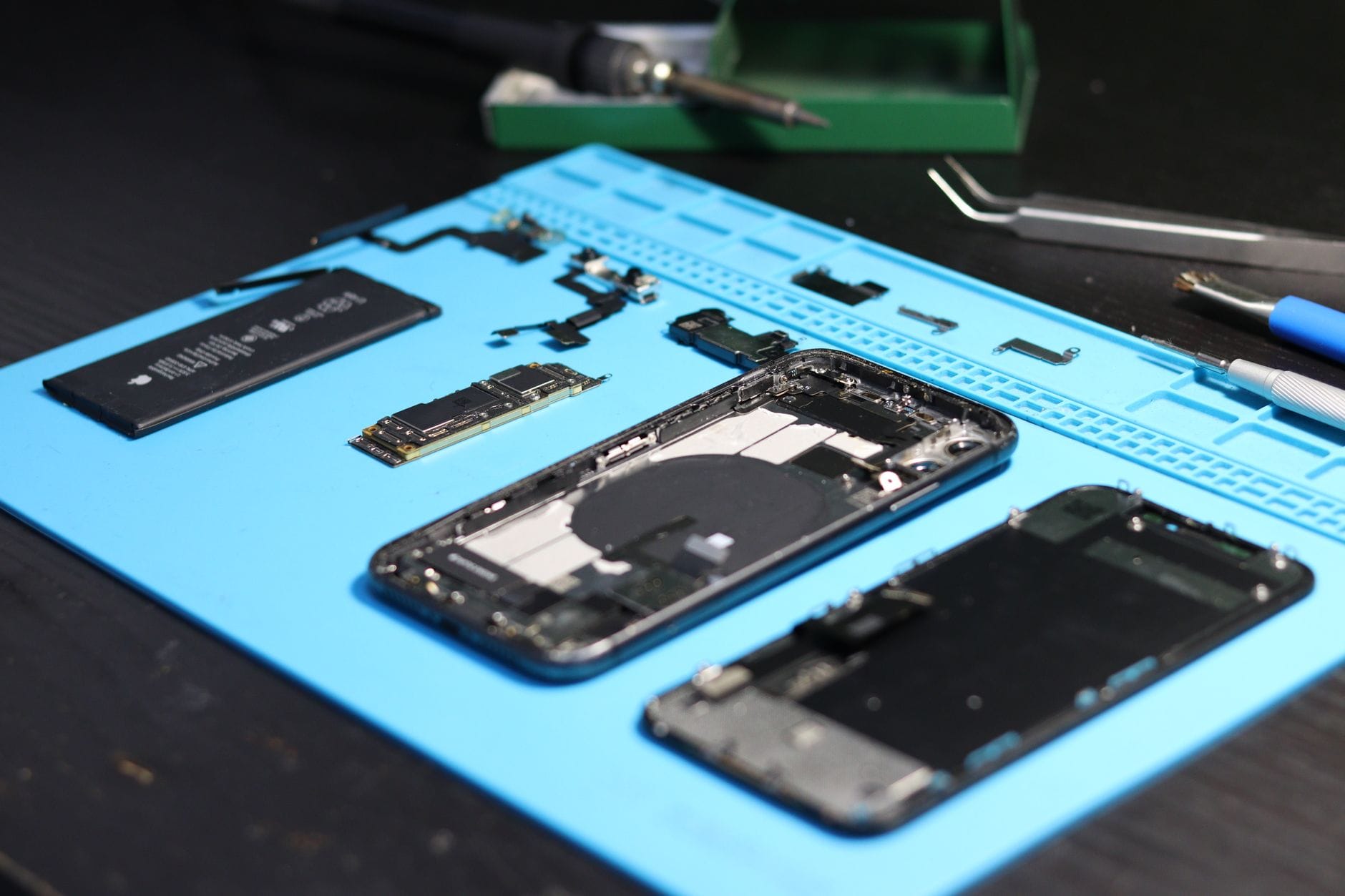 Rozłożony smartfon i narzędzia serwisowe na stole warsztatowym