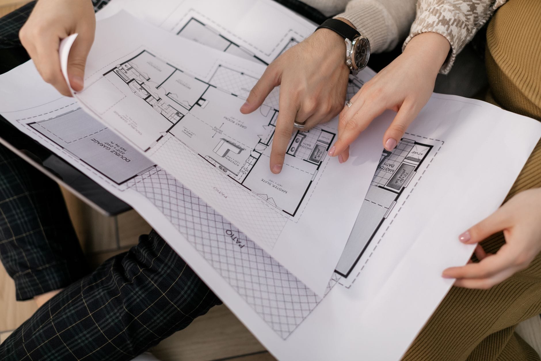 Plan miejscowy czy WZ? Jak to wpływa na Twój dom Para analizuje plany architektoniczne domu na stole