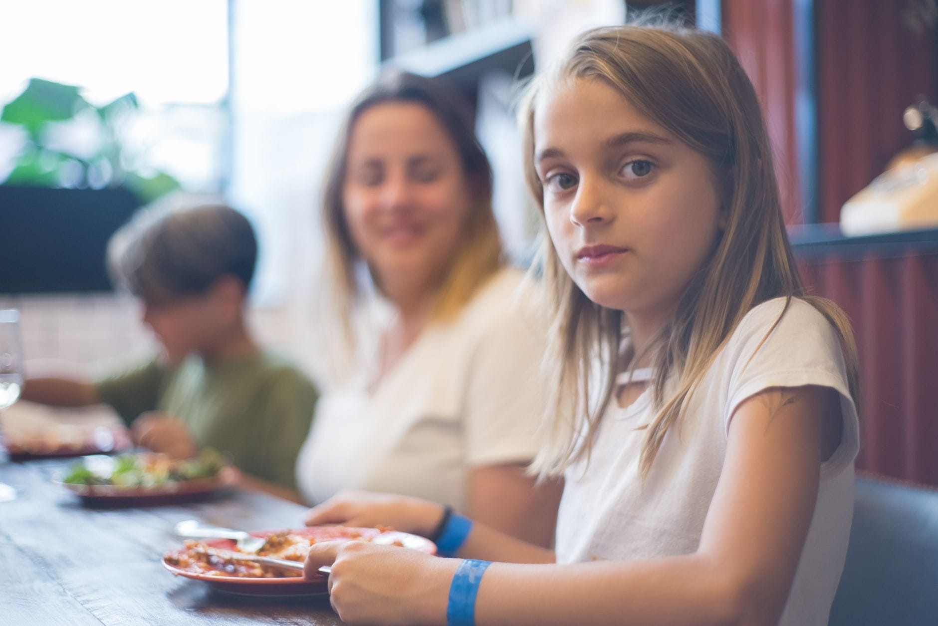Rodzina z małym dzieckiem je wspólny posiłek w restauracji