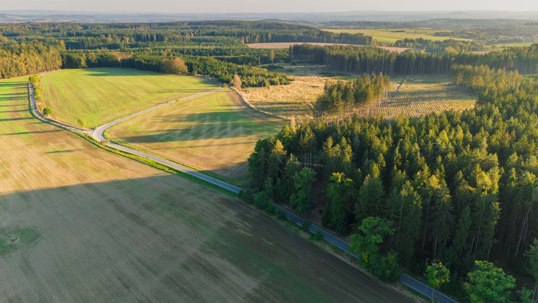 Z lotu ptaka: zielone pola i lasy na wsi, potencjalne działki pod zabudowę