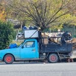 Niebieska ciężarówka załadowana odpadami do recyklingu w słoneczny dzień