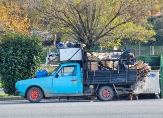 Niebieska ciężarówka załadowana odpadami do recyklingu w słoneczny dzień