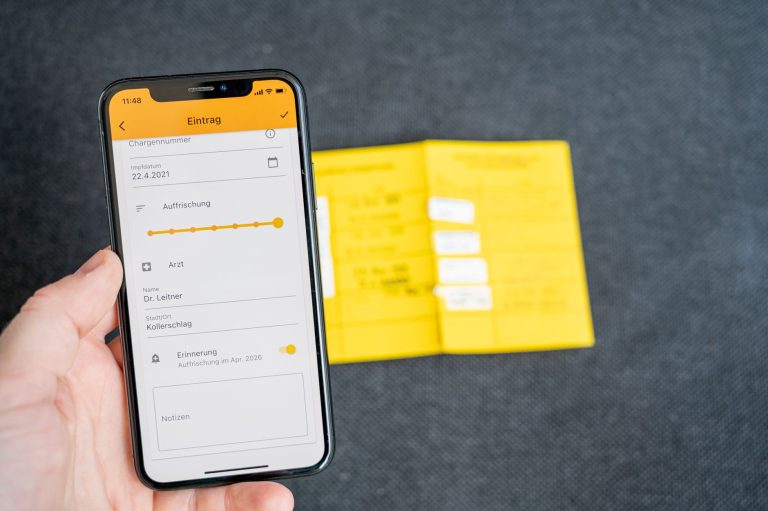 Smartfon z aplikacją medyczną i widoczną kartą szczepień